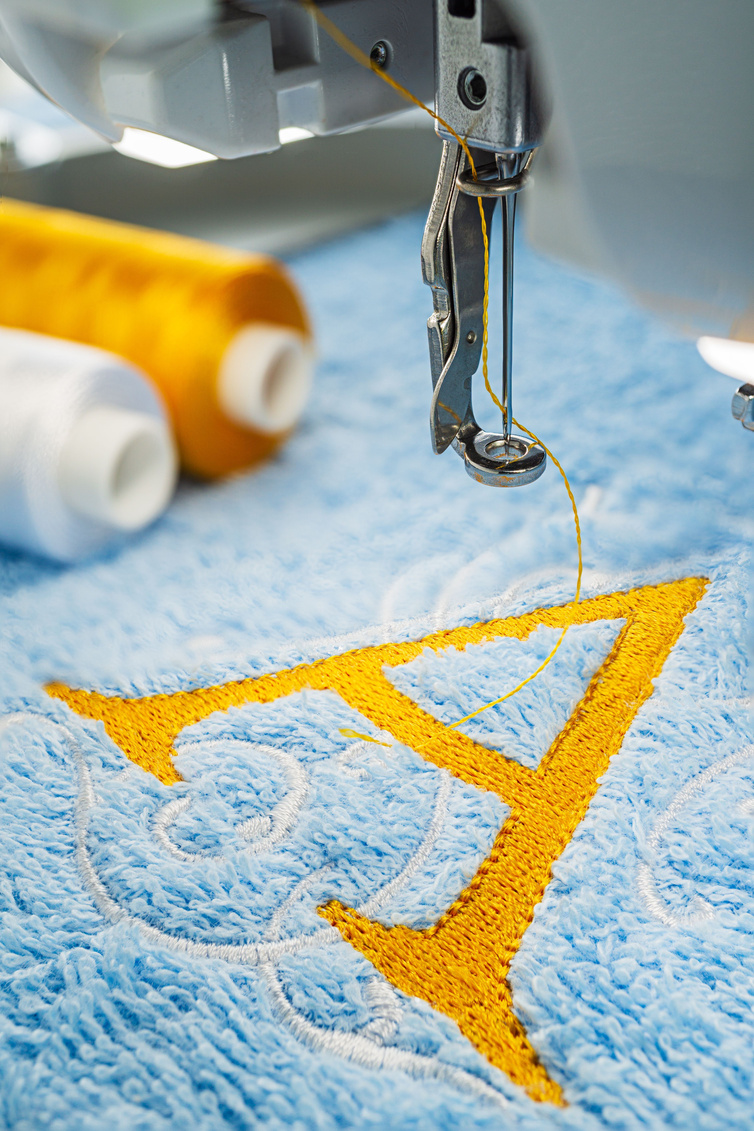 Embroidery machine and alphabet logo on towel